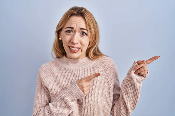 Spaanse Vrouw Staat Blauwe Achtergrond Wijzen Opzij Bezorgd Nerveus Met — Stockfoto