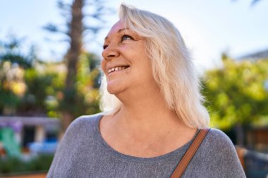 Parkta kendine güvenen orta yaşlı sarışın bir kadın.