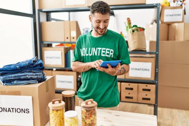 Yardım merkezinde dokunmatik ped kullanan gönüllü üniformalı bir İspanyol genç.