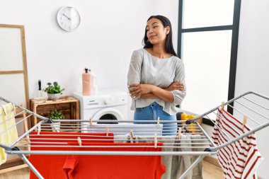 Genç İspanyol kadın çamaşır ipine yeni çamaşır koyuyor gülümseyerek yan tarafa bakıyor ve düşünüyor.. 