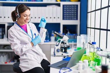 Laboratuvarda çalışan İspanyol bir kadın gülümsüyor. 