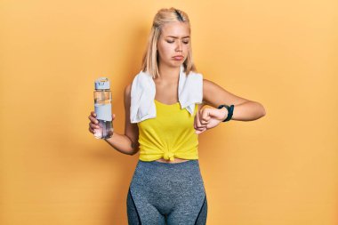 Beautiful blonde sports woman using smart watch depressed and worry for distress, crying angry and afraid. sad expression. 