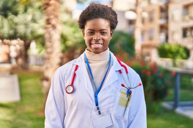 Parkta duran, doktor üniforması giyen Afrikalı Amerikalı kadın.