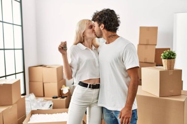 Genç ve güzel bir çift gülümsüyor. Mutlu mesut yeni evin anahtarını tutuyor..