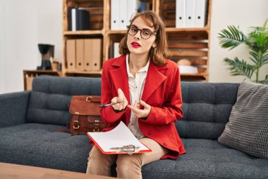 Psikoloji merkezinde konuşan beyaz kadın psikolog.