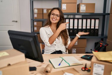 Küçük işletmelerde çalışan Latin kökenli genç bir kadın kameraya hayret ediyor ve gülümsüyor.. 