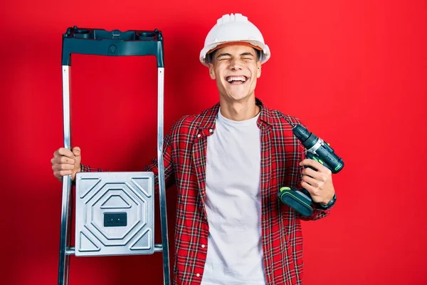 Young Hispanic Man Holding Screwdriver Wearing Hardhat Construction Stairs Smiling — Stockfoto