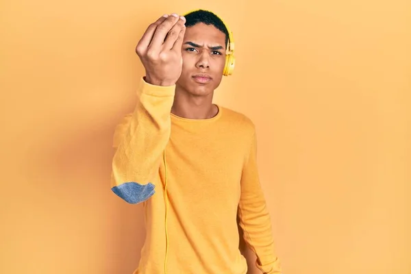 Joven Afroamericano Chico Escuchando Música Usando Auriculares Haciendo Gesto Italiano —  Fotos de Stock
