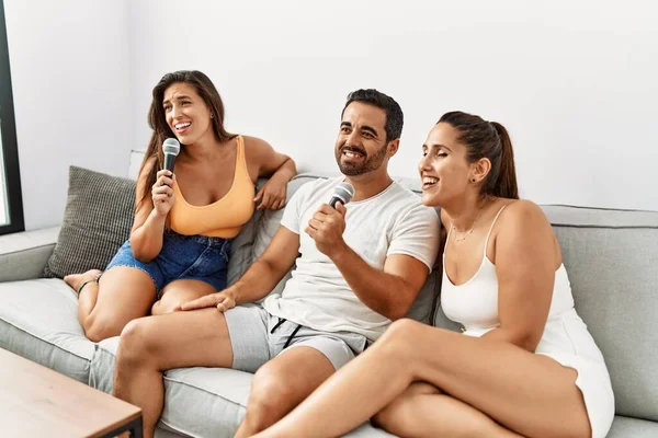 Τρεις Ισπανοί Φίλοι Χαμογελούν Χαρούμενα Τραγουδώντας Χρησιμοποιώντας Μικρόφωνο Στο Σπίτι — Φωτογραφία Αρχείου