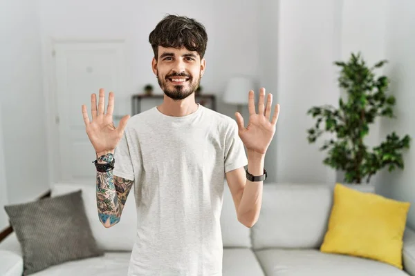 Hispanic Man Beard Living Room Home Showing Pointing Fingers Number — 스톡 사진