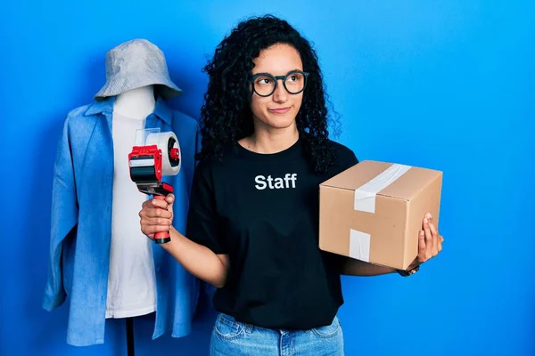 Young Hispanic Woman Curly Hair Wearing Staff Shirt Holding Cardboard —  Fotos de Stock