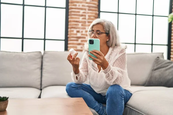 Mulher Meia Idade Usando Smartphones Segurando Pílulas Casa — Fotografia de Stock