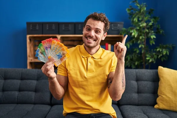 Joven Hispano Sosteniendo Billetes Franco Suizos Sonriendo Feliz Señalando Con — Foto de Stock