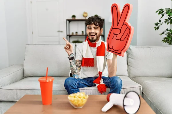 Hispanic Man Beard Supporting Football Team Home Sitting Sofa Smiling — Stockfoto