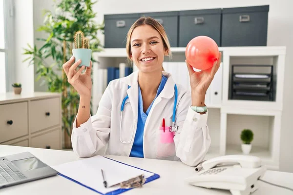 Young Blonde Woman Wearing Doctor Uniform Holding Balloon Cactus Smiling — Stok fotoğraf