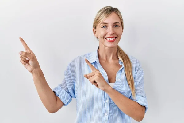 Beautiful Blonde Woman Standing White Background Smiling Looking Camera Pointing — Stockfoto