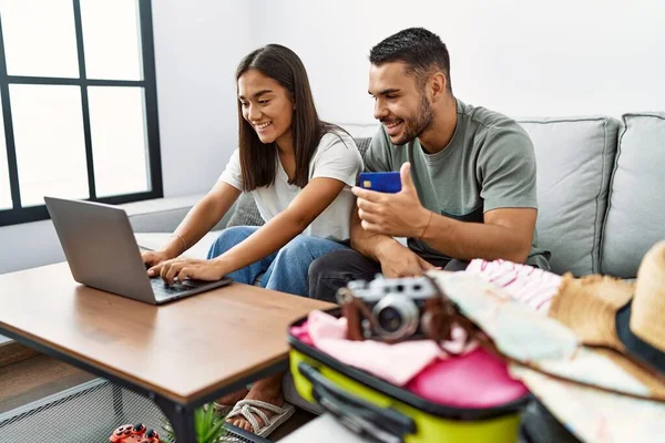 拉美男人和女人在家中使用笔记本电脑和信用卡 自信地微笑着支付旅行费用 — 图库照片