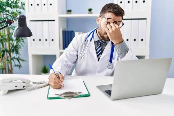 Young Hispanic Man Wearing Doctor Uniform Stressed Working Clinic — Stockfoto