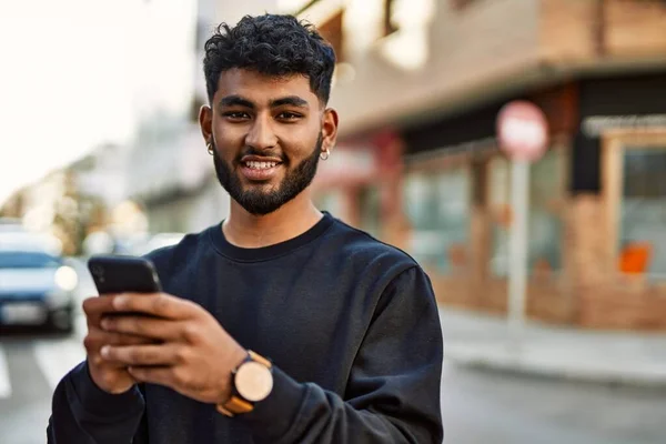 若いアラブ人男笑顔自信を持って使用してスマートフォンでストリート — ストック写真
