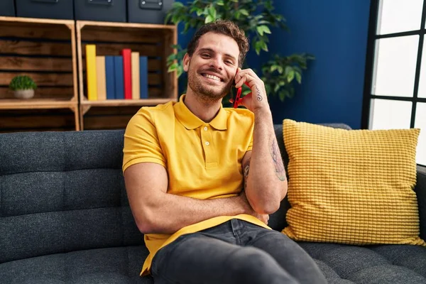 Young Hispanic Man Talking Smartphone Sitting Sofa Home — Stok fotoğraf
