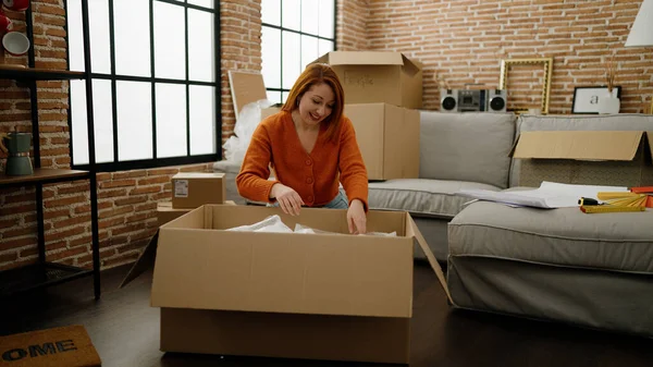 Young Redhead Woman Smiling Confident Unpacking Cardboard Box New Home — Foto de Stock