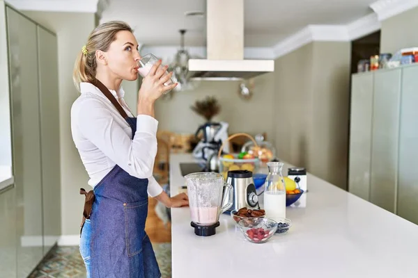 Genç Sarışın Kadın Gülümsüyor Kendine Güveniyor Mutfakta Smoothie Içiyor — Stok fotoğraf