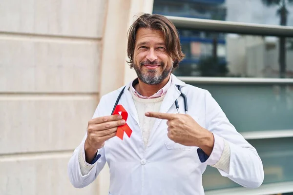Handsome Middle Age Doctor Man Holding Support Red Ribbon Smiling — Fotografia de Stock
