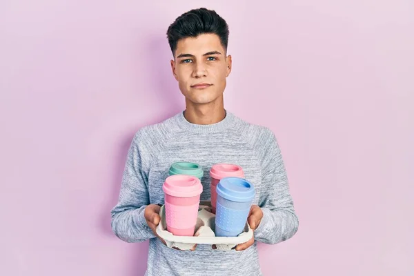 Young Hispanic Man Holding Tray Take Away Coffee Relaxed Serious — Foto Stock