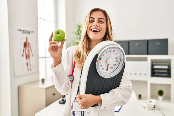 Joven Doctora Rubia Sosteniendo Máquina Pesaje Manzana Verde Sonriendo Riendo —  Fotos de Stock