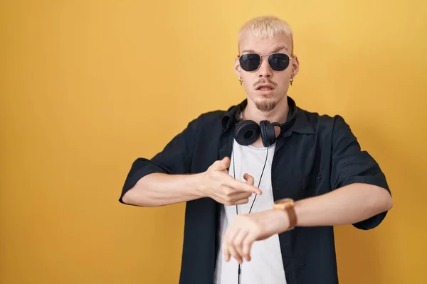 Young Caucasian Man Wearing Sunglasses Standing Yellow Background Hurry Pointing — Stock Fotó