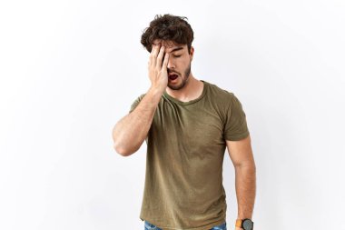 Hispanic man standing over isolated white background yawning tired covering half face, eye and mouth with hand. face hurts in pain. 