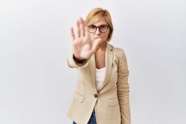Orta yaşlı sarışın iş kadını izole edilmiş arka planda durup avucuyla şarkı söylemeyi kesiyor. Yüzünde olumsuz ve ciddi bir jest olan uyarı ifadesi. 