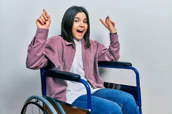 Young Brunette Woman Sitting Wheelchair Smiling Amazed Surprised Pointing Fingers — Photo