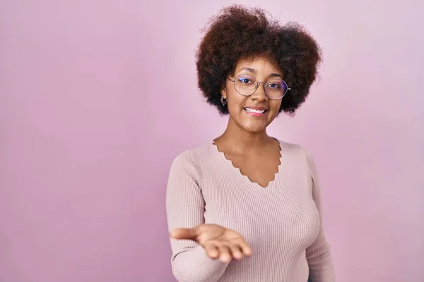 Pembe Arka Planda Duran Genç Afro Amerikan Kadın Gülümseyen Yardım — Stok fotoğraf