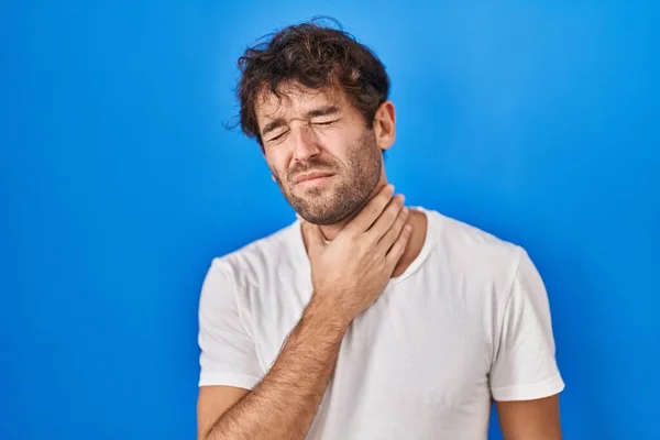 Joven Hispano Pie Sobre Fondo Azul Tocando Doloroso Cuello Dolor — Foto de Stock