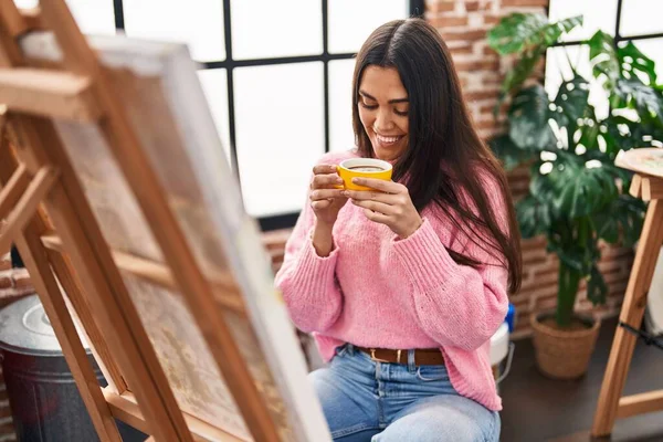 Young Hispanic Woman Drinking Coffee Looking Draw Art Studio — 图库照片