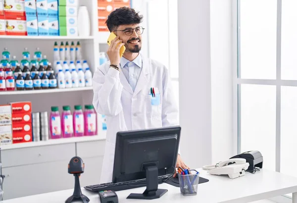 Young Hispanic Man Pharmacist Talking Smartphone Working Pharmacy — Fotografia de Stock