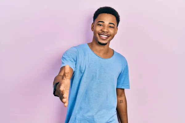 Joven Hombre Afroamericano Vistiendo Casual Camiseta Azul Sonriendo Amistoso Ofreciendo — Foto de Stock