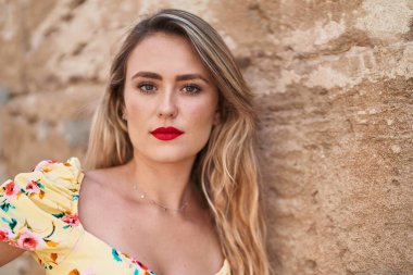 Young beautiful hispanic woman with relaxed expression standing over isolated stone background