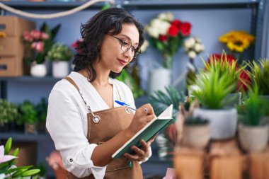 Çiçekçide kendine güvenen güzel İspanyol bir çiçekçi.