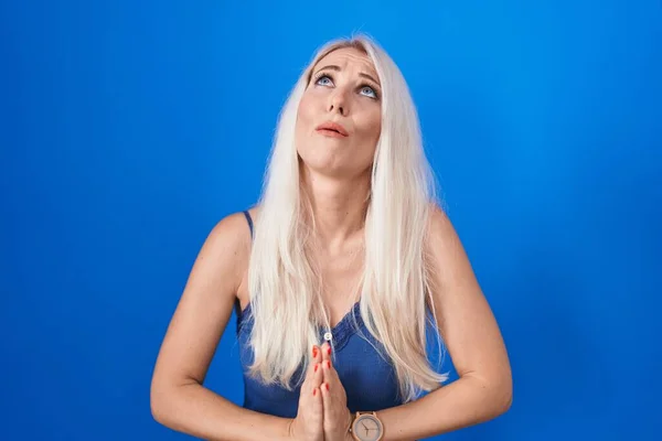 Caucasian Woman Standing Blue Background Begging Praying Hands Together Hope — Stok fotoğraf