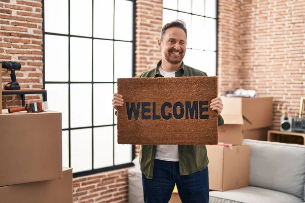 Middle Age Caucasian Man Holding Welcome Doormat New Home Winking — Fotografia de Stock