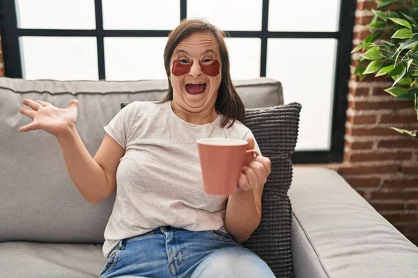 Hispanic Girl Syndrome Sitting Sofa Drinking Coffee Home Celebrating Achievement — Stockfoto
