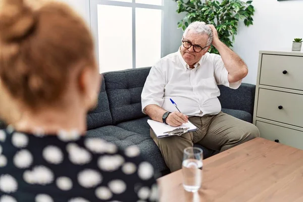 Danışma ofisindeki kıdemli psikolog soru sormayı ve kafasını karıştırıyor. Şüpheyle kararsız, kafa kafaya düşünerek. Düşünceli kavram. 