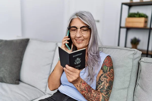 Mulher Cabelos Grisalhos Meia Idade Falando Smartphone Segurando Passaporte Casa — Fotografia de Stock