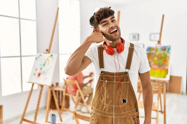 Jonge Spaanse Man Kunststudio Glimlachend Telefoongebaar Makend Met Hand Vingers — Stockfoto