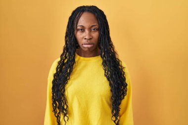 African woman standing over yellow background skeptic and nervous, frowning upset because of problem. negative person. 