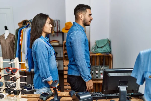 Perakende mağazasında çalışan genç ırklar arası insanlar yan bakmak, rahat profil pozu vermek, kendine güvenen bir gülümsemeyle doğal bir yüz ifadesi.. 