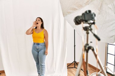 Fotoğraf stüdyosunda model gibi davranan genç ve güzel bir İspanyol kadın el ele tutuşarak bağırıyor ve çığlık atıyordu. iletişim konsepti. 