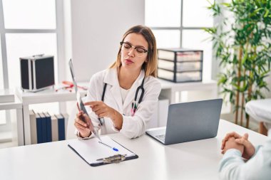 Genç adam ve kadın doktor ve hasta klinikte tıbbi danışmanlık yapıyorlar.